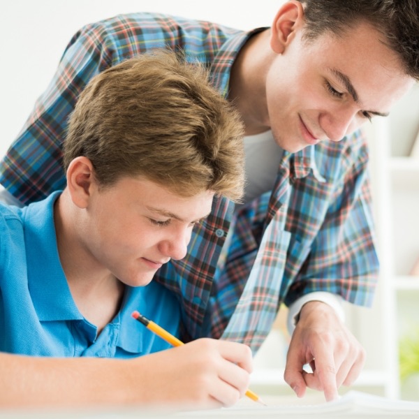 A tutor helping a middle school student with his written work