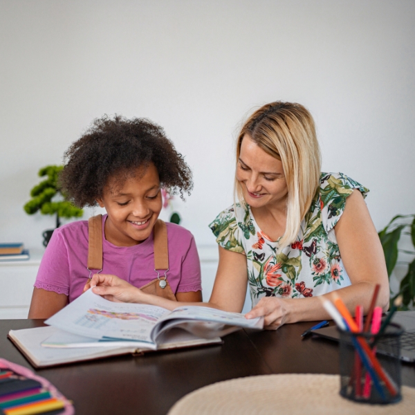 child and tutor looking at homework