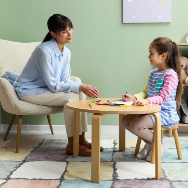 child at table with therapist